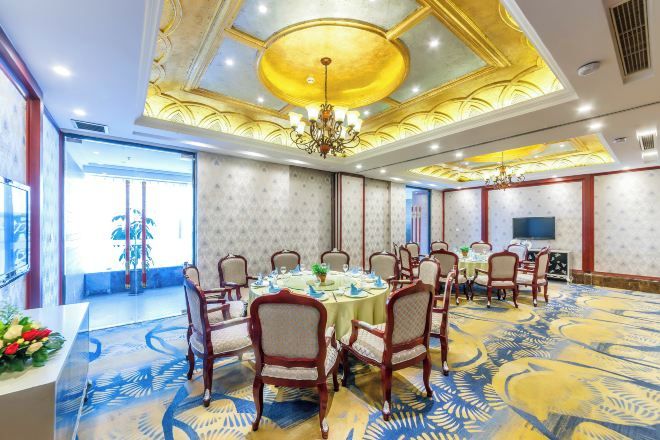 Un salón de conferencias con una mesa redonda, sillas y una araña.