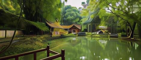 A traditional building with a tiled roof, surrounded by lush greenery and a calm pond.
