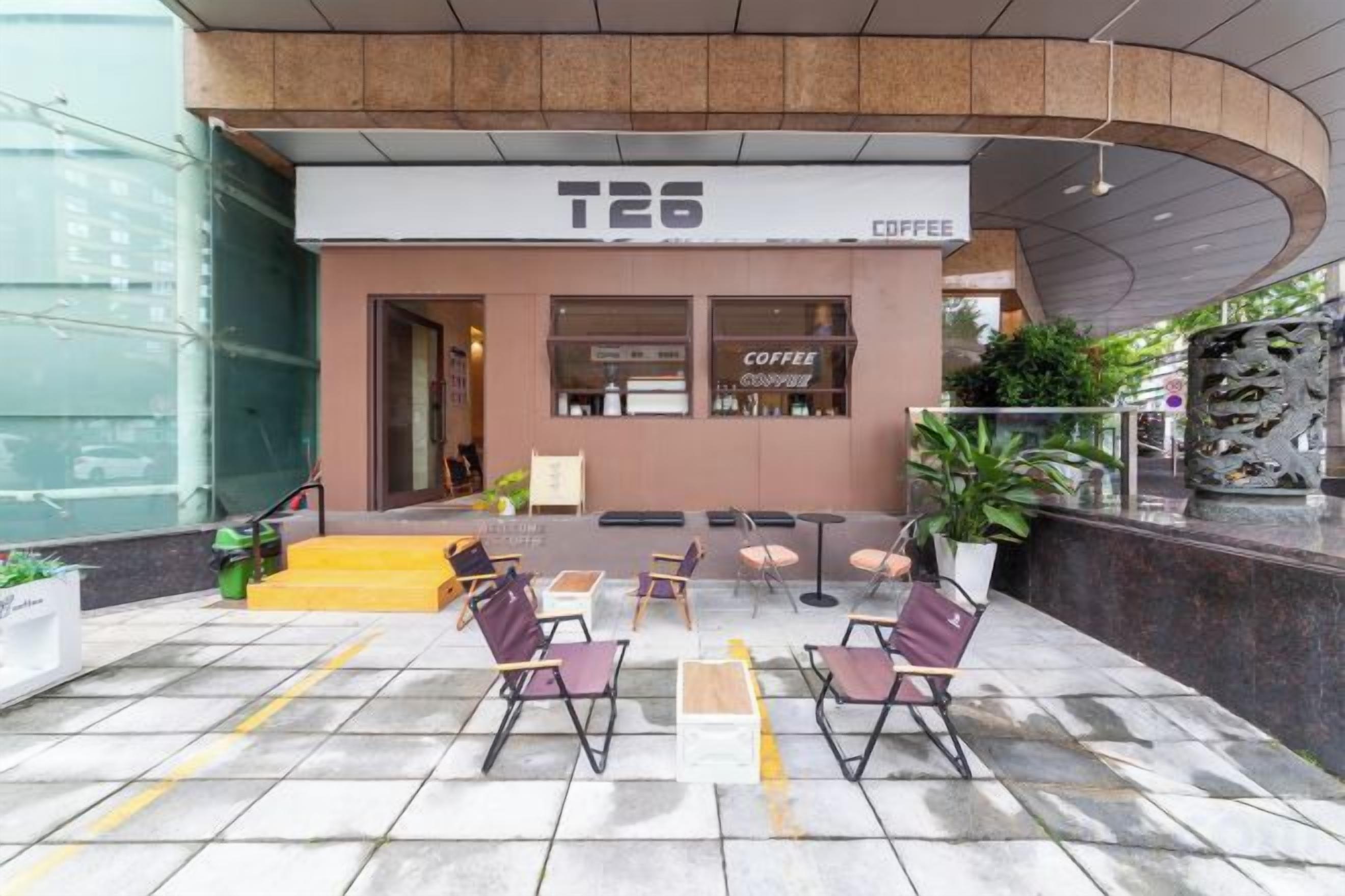 A coffee shop named T26 with outdoor seating and a modern design.