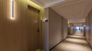 A hotel corridor with wooden doors, numbered room signs, and a carpeted floor. - Forstar Hotel (Chengdu Renmin North Road) (Chengdu)
