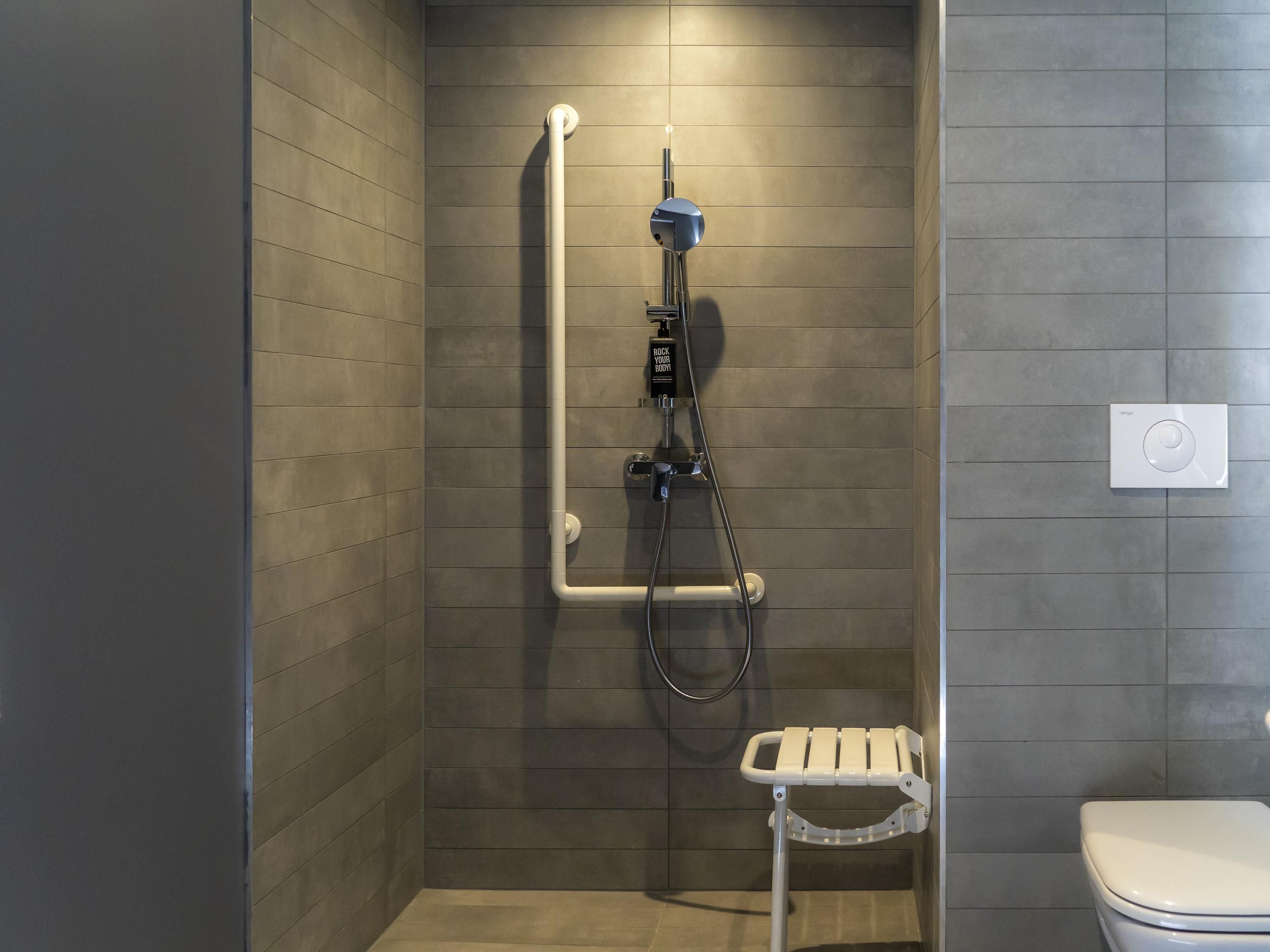 A shower with a handheld showerhead, a handheld showerhead, and a handheld showerhead.