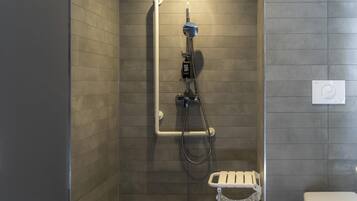 A shower with a handheld showerhead, a handheld showerhead, and a handheld showerhead.