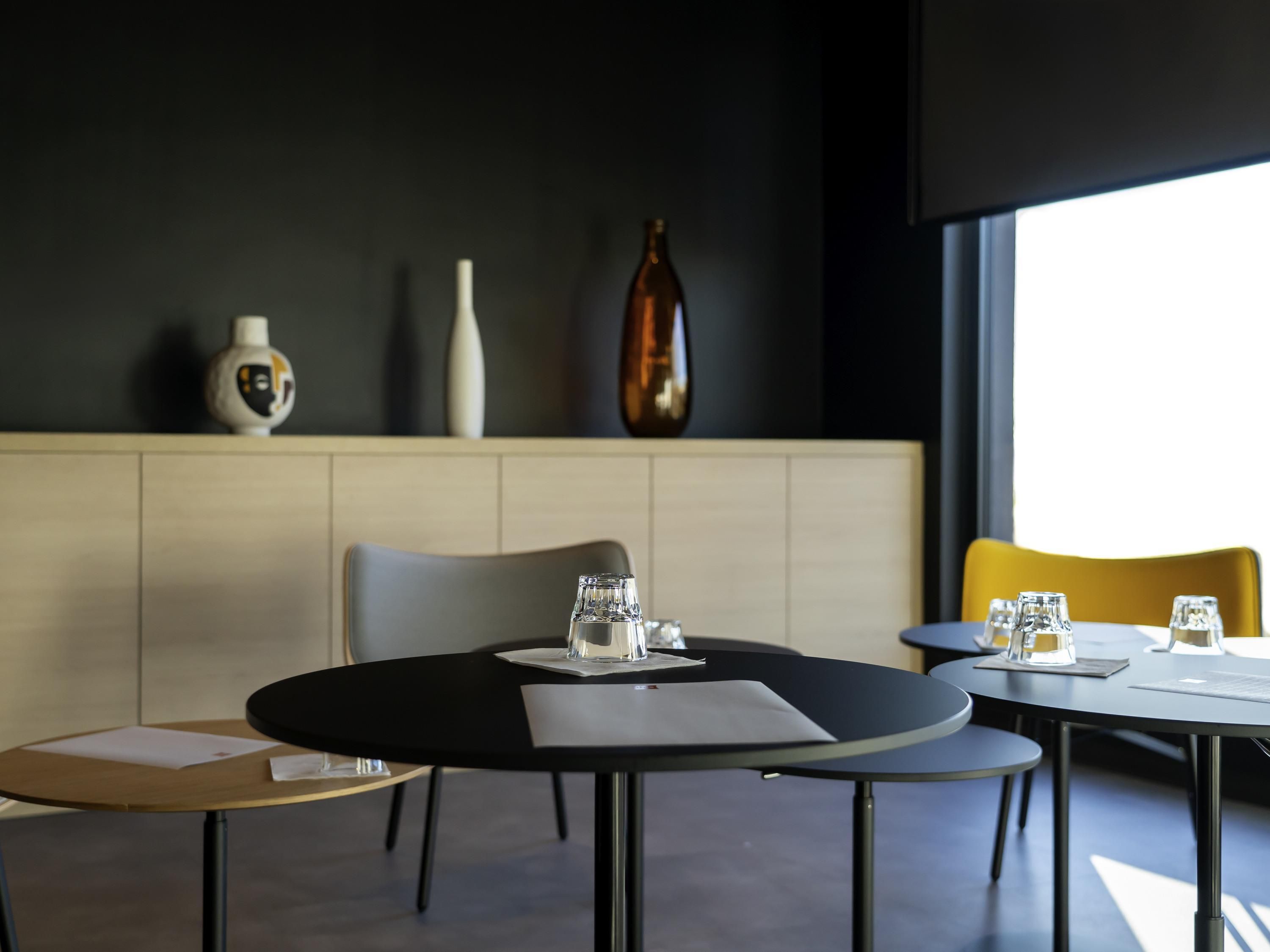 Un comedor moderno con mesas redondas, sillas y una decoración minimalista.