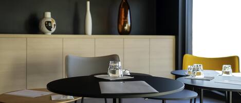 Un comedor moderno con mesas redondas, sillas y una decoración minimalista.