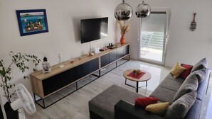 A modern living room with a sofa, a coffee table, a TV, and a console table with decorative items. - Attractive holiday house near the sea! (Vinjerac)