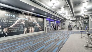 A gym with exercise equipment, motivational posters, and a patterned carpet. - Crystal City Apartments near Crystal Park - We Host (Arlington)
