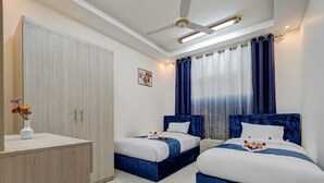 Ein Hotelzimmer mit zwei Betten, einem Kleiderschrank und einem Deckenventilator.