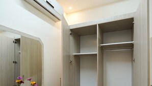 Ein modernes Badezimmer mit einem Holzwaschtisch, einem Spiegel und einer eingebauten Garderobe mit Regalen.