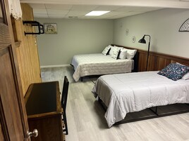Un dormitorio con dos camas, un escritorio y una silla.