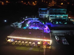 A hotel with a pool area, outdoor seating, and a two-story building in the background. - Hotel Restaurant Falucho Paradise Beach (Santa Cruz)