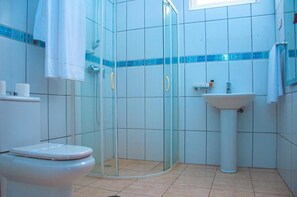 A bathroom with a glass-enclosed shower, a white toilet, and a pedestal sink. - Hotel Restaurant Falucho Paradise Beach (Santa Cruz)