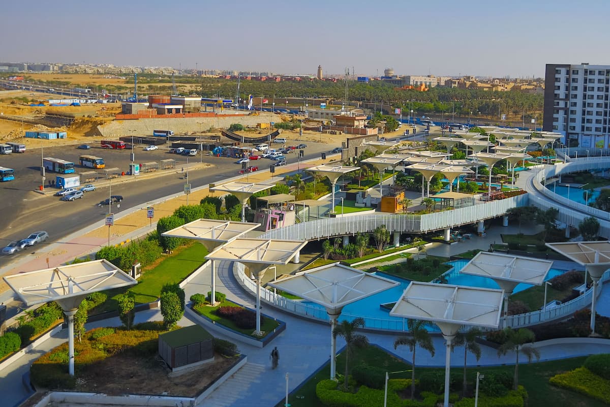 A modern hotel with a central courtyard, outdoor seating areas, and a view of the surrounding cityscape.
