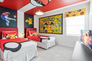Een kamer met twee bedden, een groot kunstwerk met Pokémon-thema, een plafondventilator en een raam met jaloezieën.