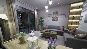 A modern living room with a sofa, coffee table, and decorative plants. - Royal Hill Villa (Hersonissos)