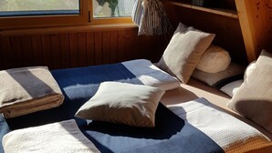 Un dormitorio acogedor con cama, almohadas y ventana con vistas a un jardín.