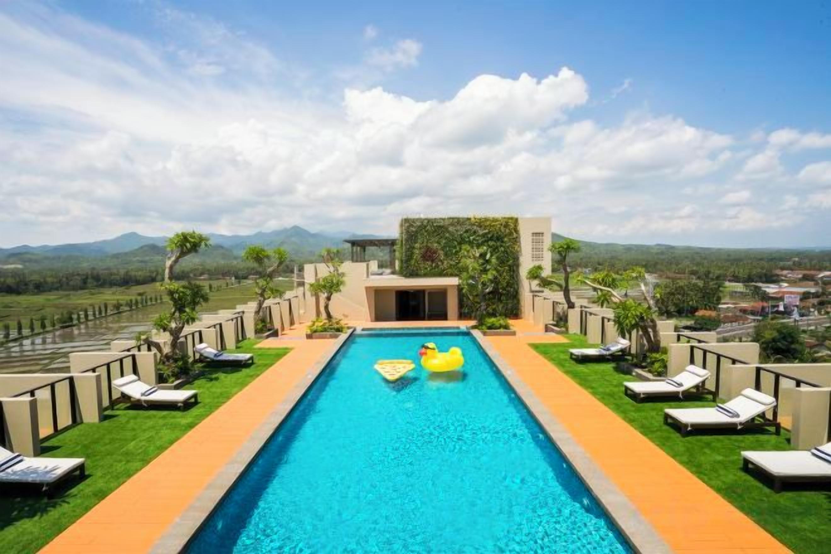A swimming pool with lounge chairs and a view of the landscape.