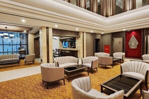 A hotel lobby with a seating area, a bar, and a fireplace. - Swiss-Belhotel Airport Yogyakarta (Temon)