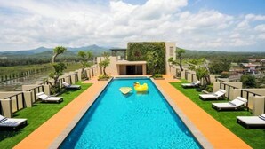 Una piscina con lettini e vista sulle montagne.