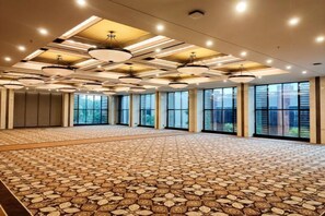 A large conference room with patterned carpet, multiple windows, and modern ceiling lighting. - Swiss-Belhotel Airport Yogyakarta (Temon)