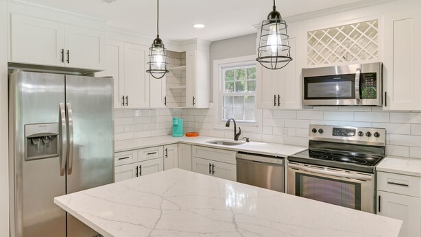 A modern kitchen with white cabinetry, stainless steel appliances, and a marble countertop. - Hampton Bays Retreat: Walk to Squires Beach! (Hampton Bays)