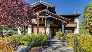 A modern building with a stone staircase leading to a wooden door, surrounded by lush greenery. - Sun Valley Condo w/ Furnished Patio: Near Skiing! (Sun Valley)