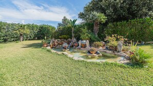 A well-maintained garden with a small pond, various plants, and a clear sky. - Villa Ca Na Francisca - By Dream Villas Pollensa (Pollensa)