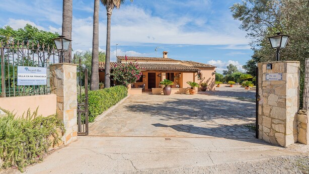 A villa entrance with a stone pathway, palm trees, and a sign indicating 'Villa Na Francisa'. - Villa Ca Na Francisca - By Dream Villas Pollensa (Pollensa)