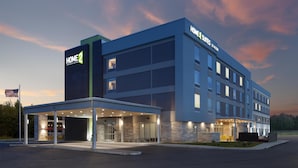 A modern hotel with a covered entrance, multiple floors, and a sign reading "HOME 2 Suites." - Home2 Suites By Hilton Jackson (Jackson)