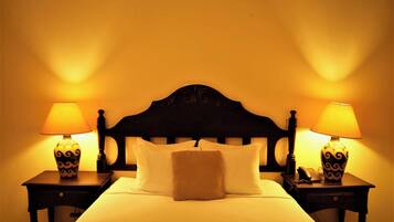 A hotel room with a bed, two bedside tables with lamps, and a headboard.