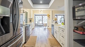 A modern kitchen with a skylight, stainless steel appliances, and a view to the dining area.