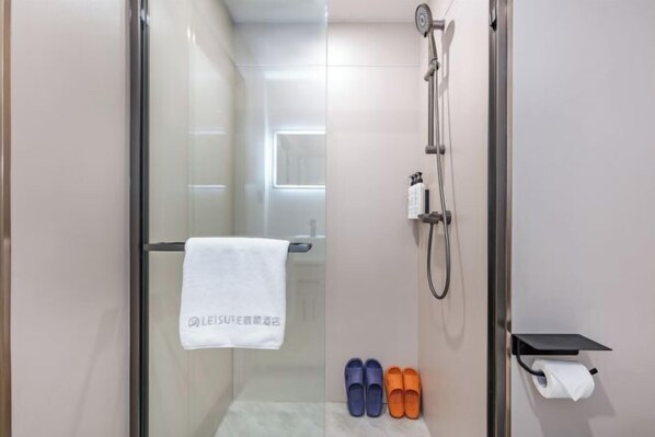 A modern bathroom with a glass shower enclosure, a towel hanging on the door, and a pair of slippers on the floor. - Elong ME Hotel (Binhai High-Speed Railway Station) (Tianjin)