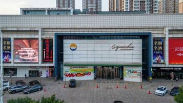 A commercial building with a large sign for Gungdoh, multiple storefronts, and a parking lot with cars.