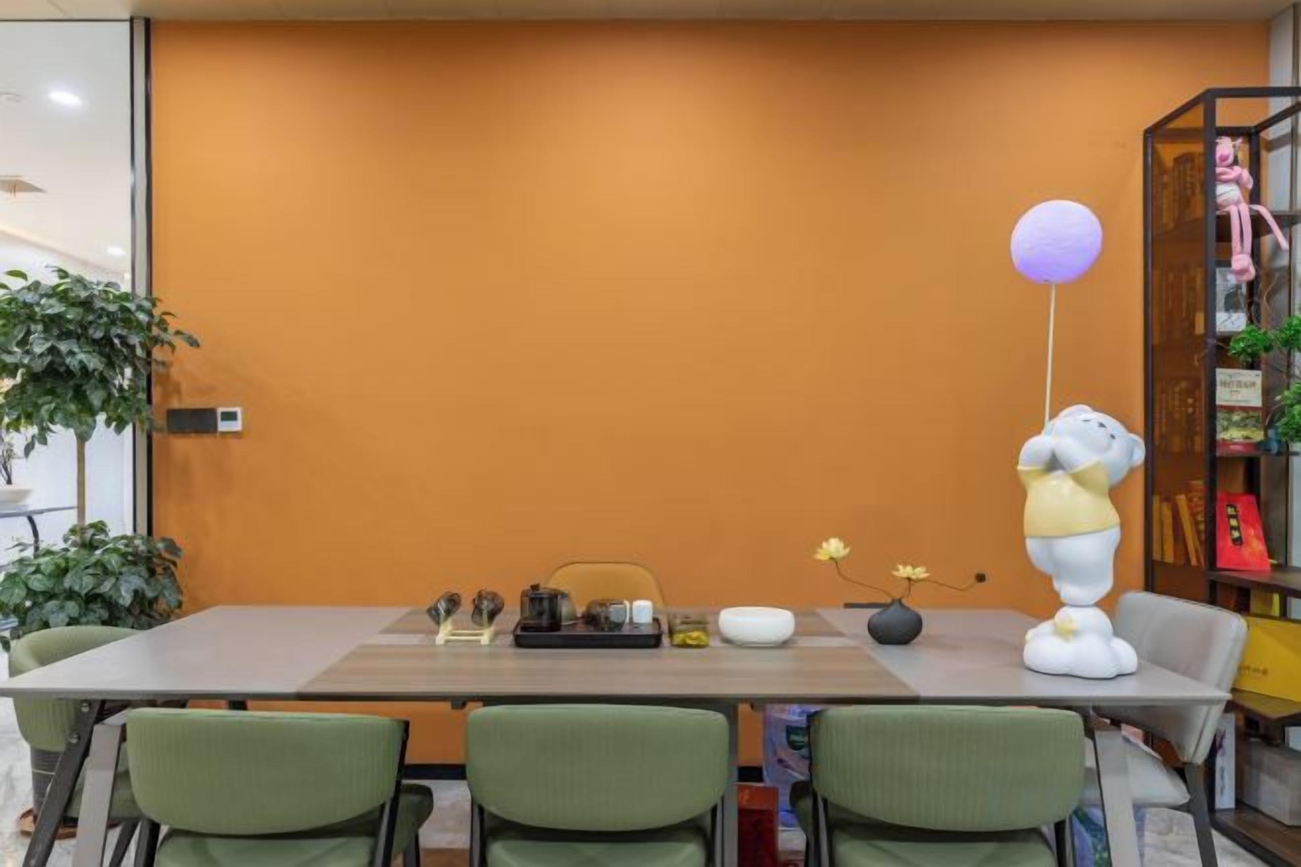 Sala de conferência com uma mesa comprida, cadeiras e uma estátua decorativa de elefante segurando um balão.