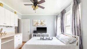 A bedroom with a bed, a ceiling fan, a TV, and a window with curtains. - Clean&Cozy 3 bedroom 2 bath home No cleaning fees
 (Fresno)