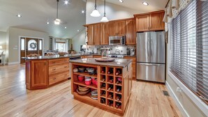 Eine geräumige Küche mit Holzschränken, Edelstahlgeräten und einem Weinkühlschrank.