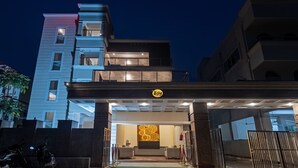 A modern building with a reception area featuring a logo, a reception desk, and a seating area. - Itsy Hotels Greenland Jungle View (Bhubaneshwar)