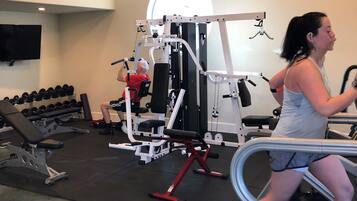 Ein Fitnessstudio mit Cardiogeräten, Krafttrainingsgeräten und Kurzhanteln.