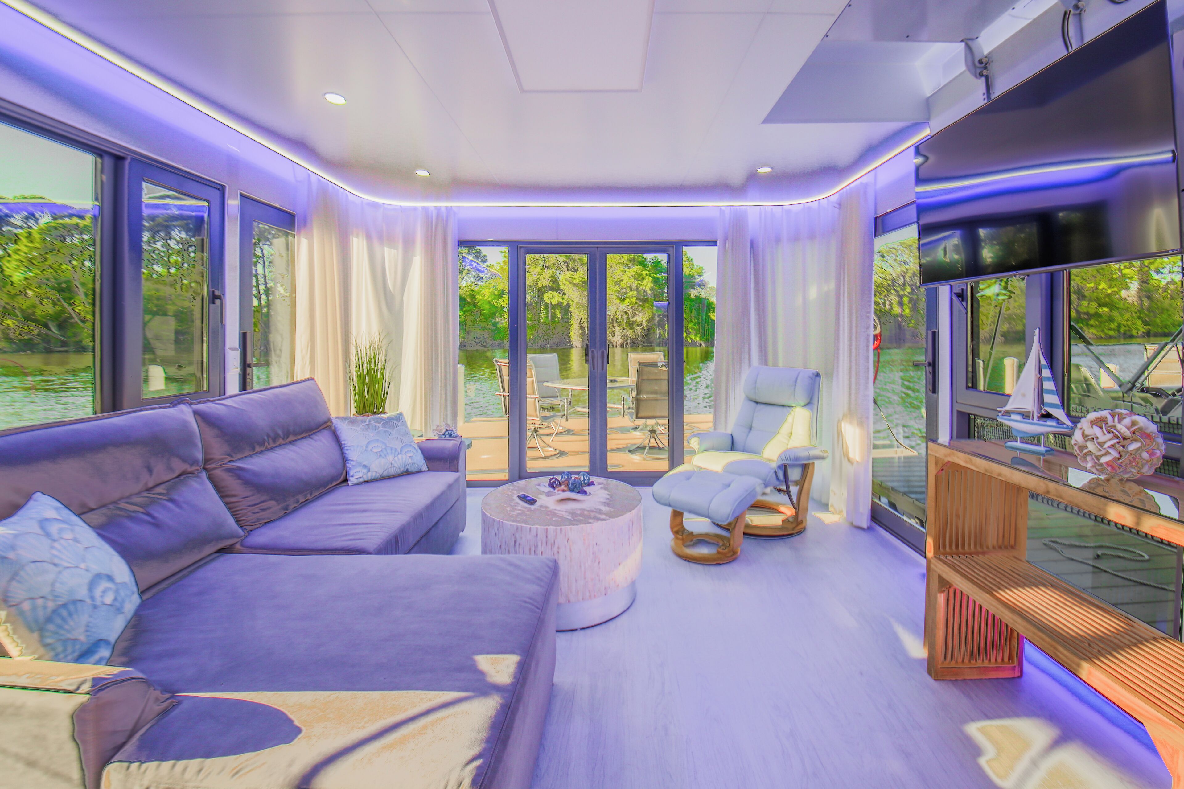 A modern living room with a large sofa, a round coffee table, and a glass partition.