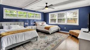 A bedroom with two beds, a ceiling fan, and large windows. - Christian Brothers Getaway (Memphis)