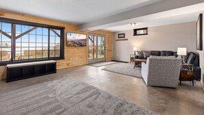 A spacious living room with a large window, a fireplace, and a cozy seating area. - LAKE HOME ON PELICAN!! Just a short walk away from food, live music, & golf! (Breezy Point)