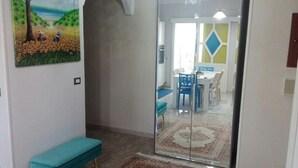 Un pasillo con un banco, un tapete y un cuadro en la pared.