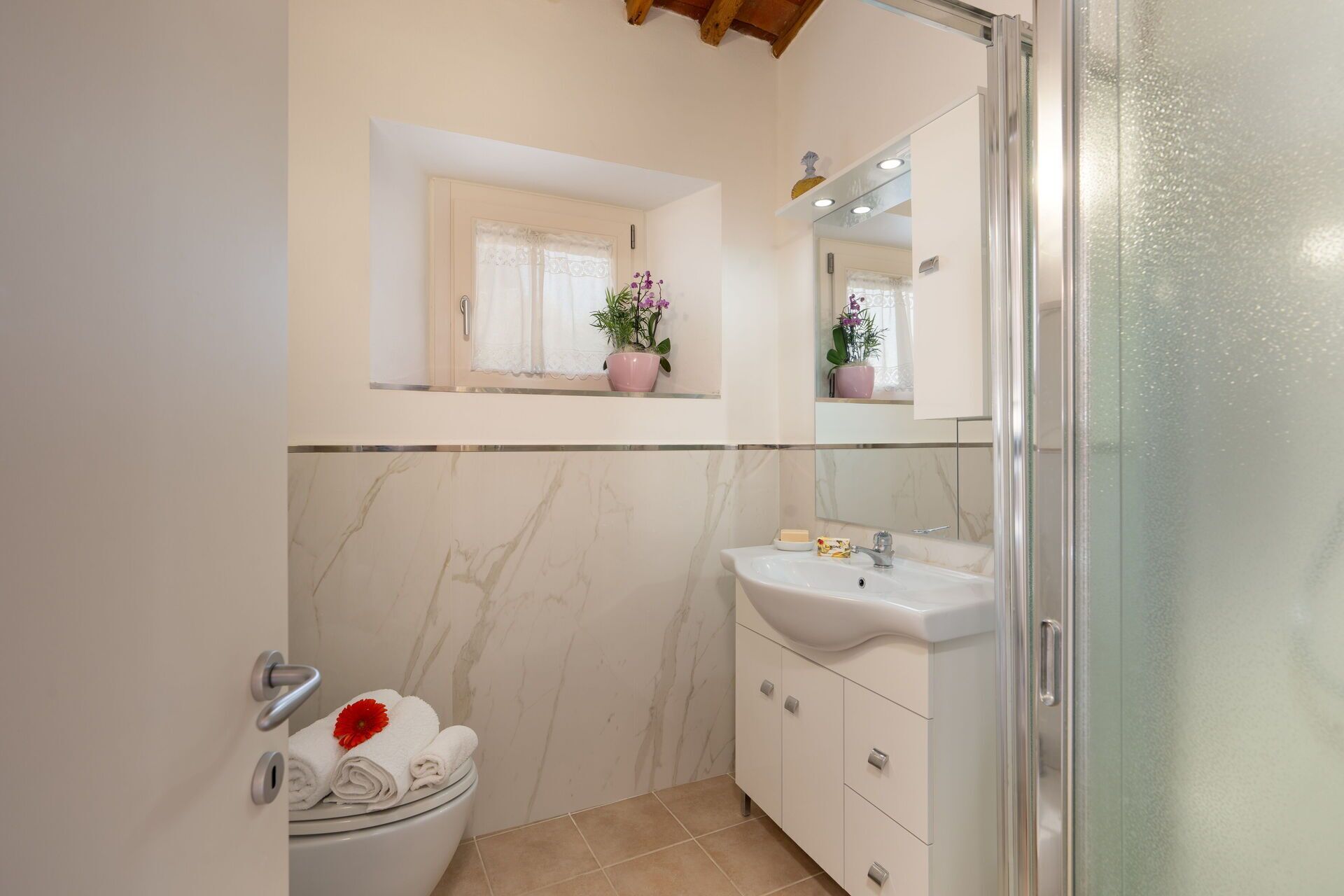 A bathroom with a toilet, sink, and shower.