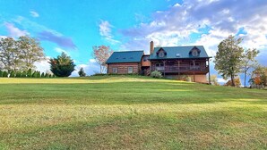 A large log cabin with a balcony, surrounded by a well-maintained lawn and trees. - Luxurious cabin, mountain views near the  Smokies! 
Pet and family friendly! (Newport)