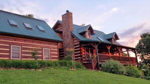 A log cabin with a green metal roof, a stone chimney, and a porch with wooden railings. - Luxurious cabin, mountain views near the  Smokies! 
Pet and family friendly! (Newport)