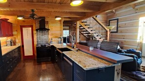 A kitchen with wooden walls, a black refrigerator, a stove, and a sink. - Luxurious cabin, mountain views near the  Smokies! 
Pet and family friendly! (Newport)