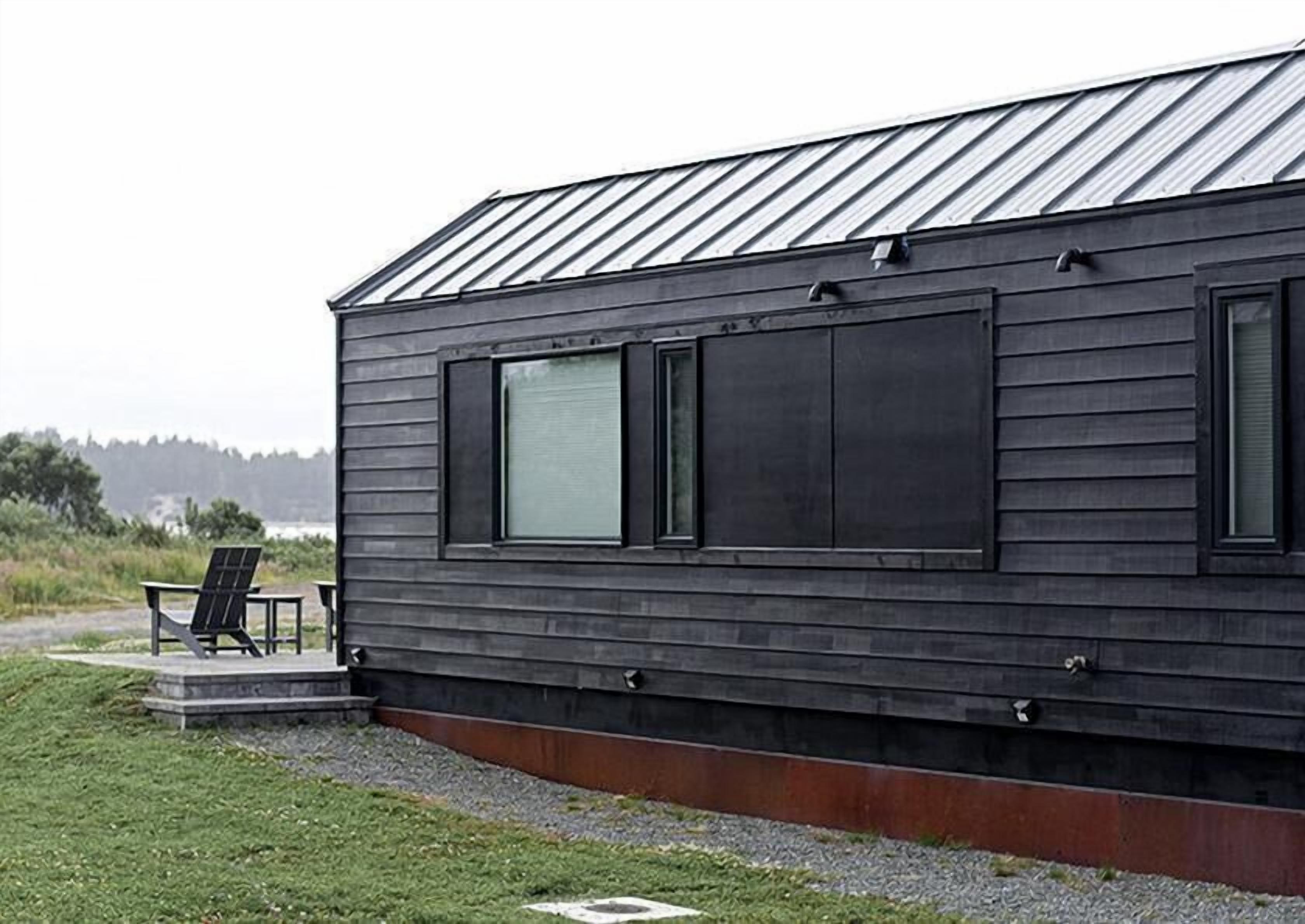 Een modern gebouw met een metalen dak en grote ramen.