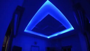 A room with a geometric ceiling design and a door in the background. - Modern Apartment in La Ceiba ‼️No Cleaning Fee‼️ (La Ceiba)