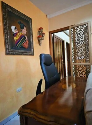 Un comedor con una mesa de madera y una silla negra.