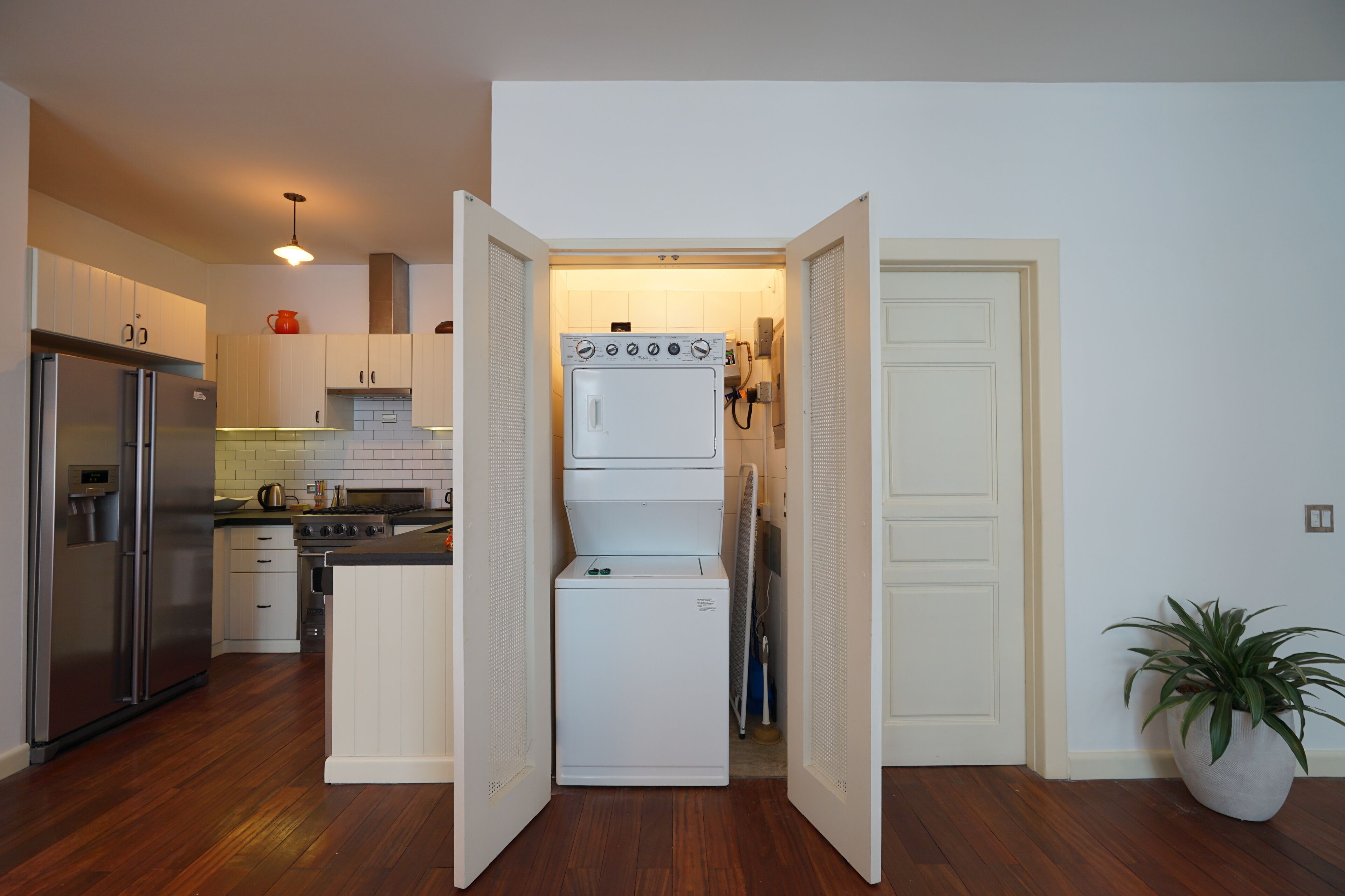 A compact kitchen with a refrigerator, stove, and washing machine.