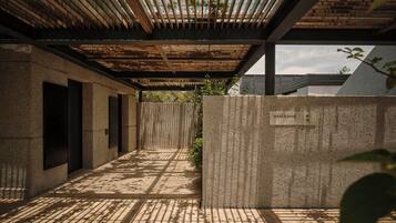A modern architectural design with a concrete wall, a wooden ceiling, and a metal door.